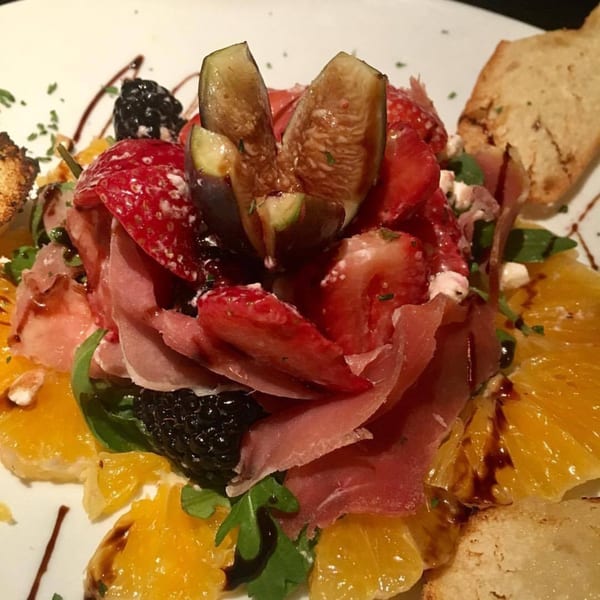 Italian salad with prosciutto, figs, strawberries, oranges, blackberries, arugula, and balsamic glaze.